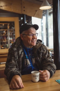 Jari Olkkola istuu Kylmäluoman retkeilykeskuksen kahvilassa