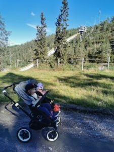Lapset istuvat lastenvaunuissa Rukan maisemissa