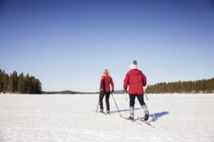 Kaksi henkilöä hiihtämässä järven jäällä