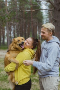 Janikalla on sylissä Rane-koira, Anttu seisoo vieressä