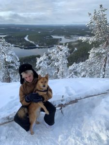 Henkilö koiran kanssa Konttaisen huipulla talvimaisemissa
