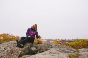 Kukka Laakso istuu kalliolla kahvakuula vieressään