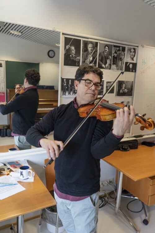 Claudio Ordaz soittamassa viulua työhuoneessaan.