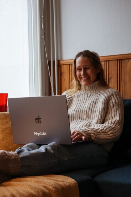 Charlotta sohvalla tietokone sylissään.