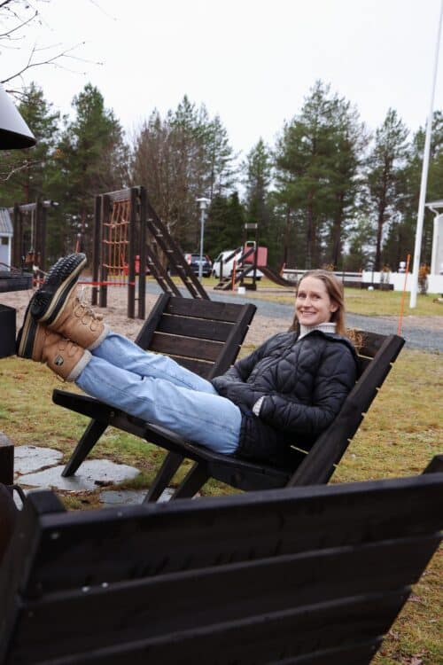 Charlotta istumassa tuolilla rivitalon pihalla.