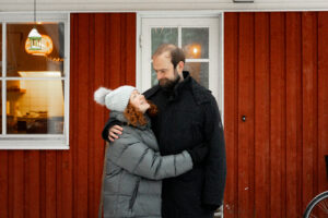 Katja ja Richard vuokrakotinsa ulkoterassilla. He halaavat ja katsovat toisiaan.